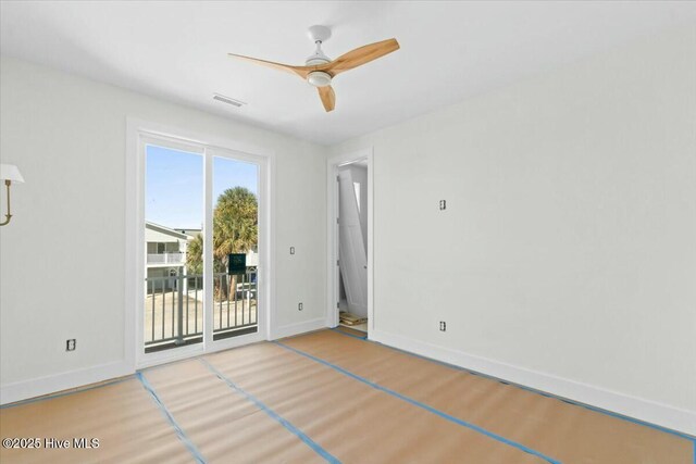 unfurnished room with ceiling fan, visible vents, baseboards, and wood finished floors