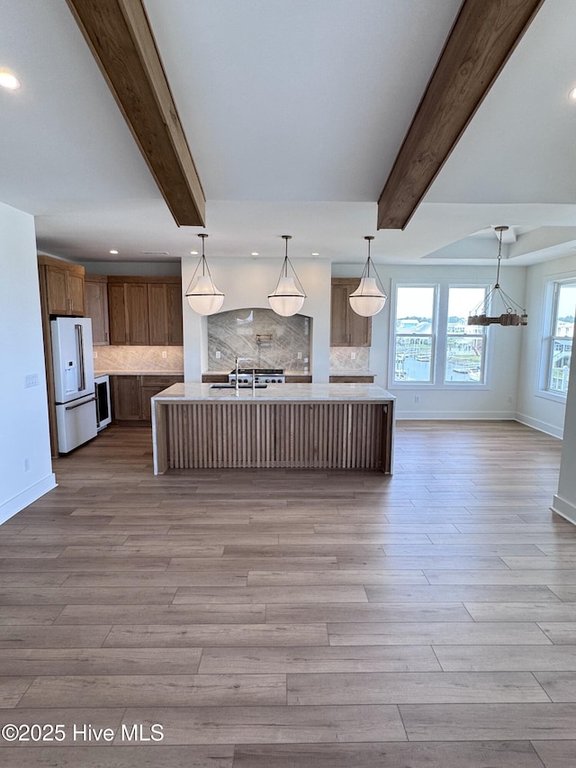 36 Fairmont St, Ocean Isle Beach, NC 28469 - kitchen featuring high end fridge, beam ceiling, baseboards, light countertops, and backsplash