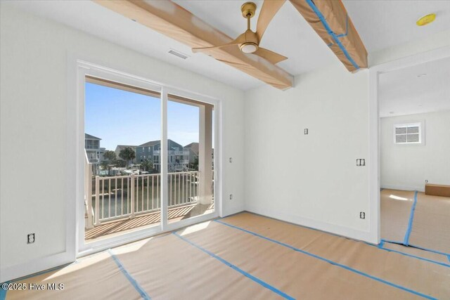 spare room with visible vents, baseboards, ceiling fan, beamed ceiling, and wood finished floors