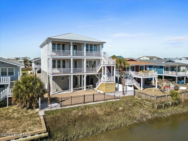36 Fairmont St, Ocean Isle Beach, NC 28469 - rear view of house featuring a patio, a balcony, a fenced backyard, a water view, and stairway