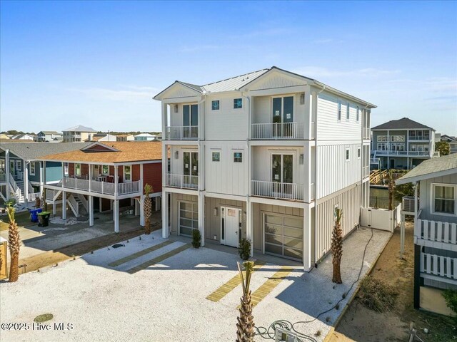 view of front of home featuring driveway, a standing seam roof, a residential view, an attached garage, and metal roof