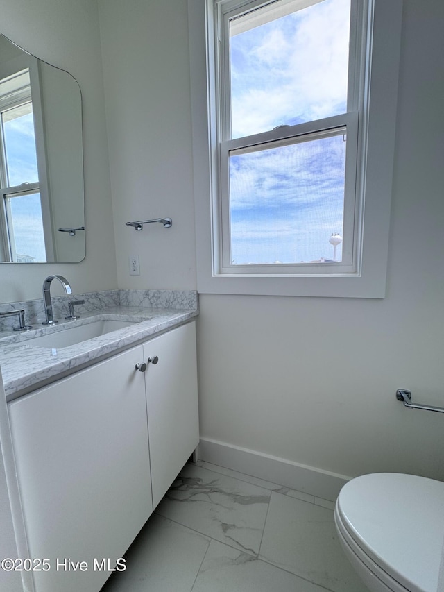 36 Fairmont St, Ocean Isle Beach, NC 28469 - half bathroom with baseboards, marble look tiles, vanity, and toilet