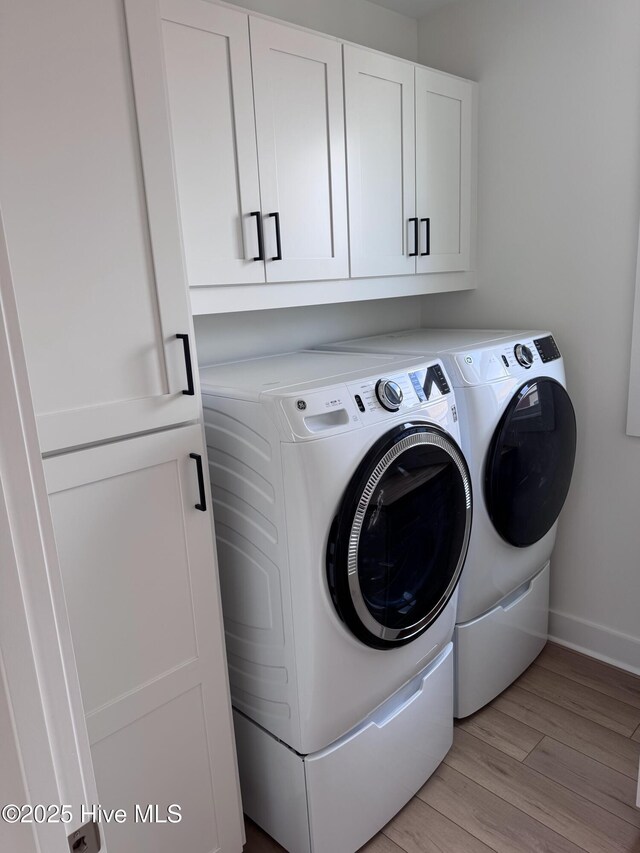 36 Fairmont St, Ocean Isle Beach, NC 28469 - laundry area featuring washer and clothes dryer, cabinet space, light wood finished floors, and baseboards
