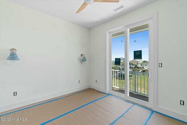 spare room featuring baseboards, visible vents, and ceiling fan