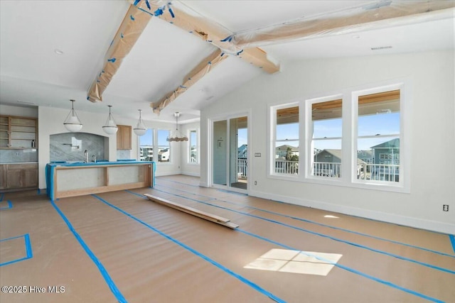 exercise room with vaulted ceiling, baseboards, and a sink