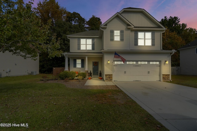 view of front of house featuring cooling unit, a garage, and a lawn