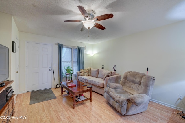 living room with ceiling fan, a textured ceiling, and light hardwood / wood-style flooring