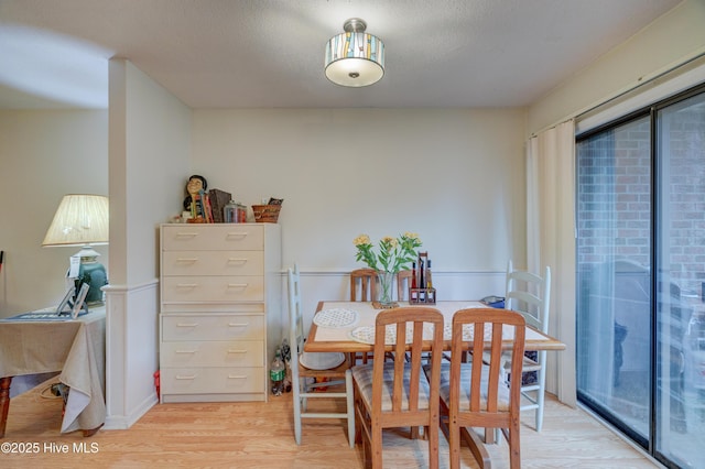 dining room featuring a textured ceiling, light hardwood / wood-style flooring, and a wealth of natural light