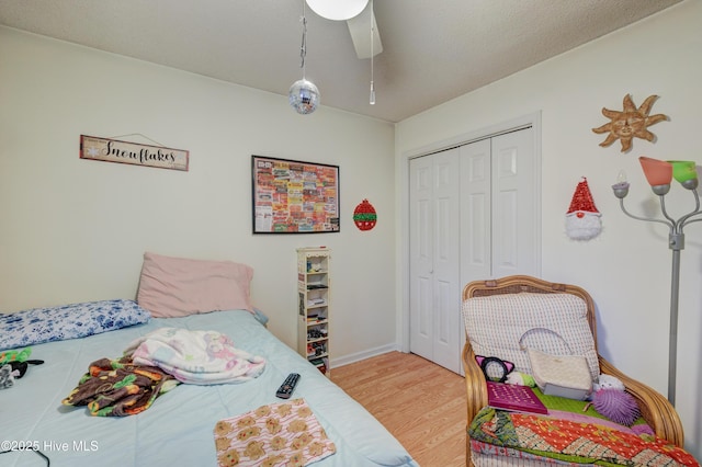 bedroom featuring hardwood / wood-style flooring, ceiling fan, and a closet