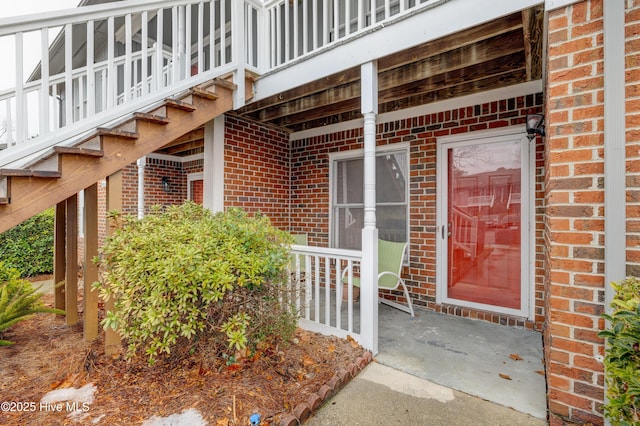 view of exterior entry with a balcony