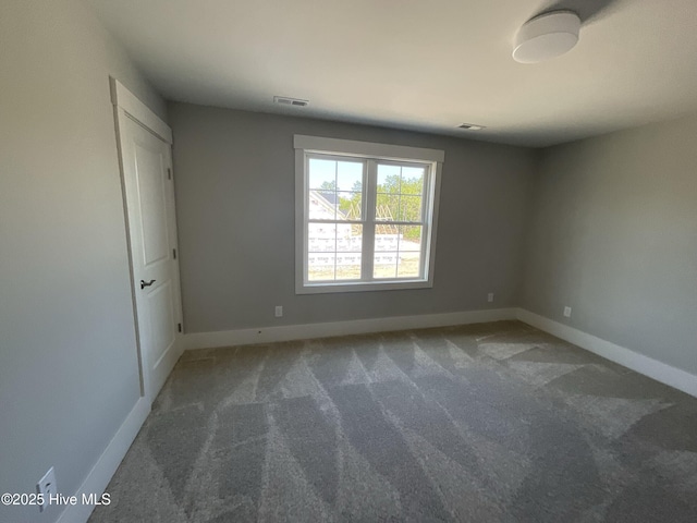 spare room featuring carpet, baseboards, and visible vents