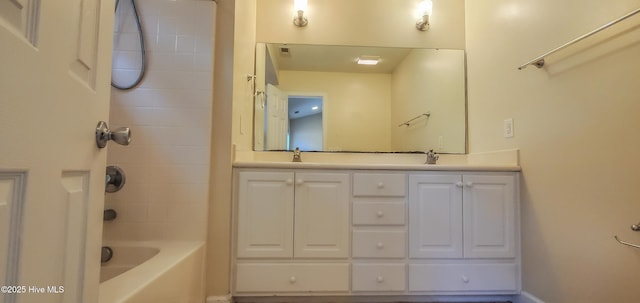 bathroom featuring tiled shower / bath combo and vanity