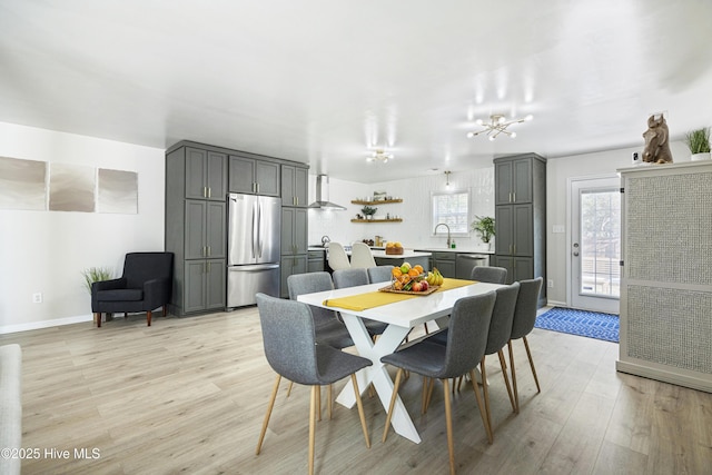 dining area with sink and light wood-type flooring