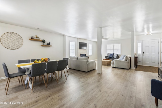 dining room featuring a large fireplace and light wood-type flooring