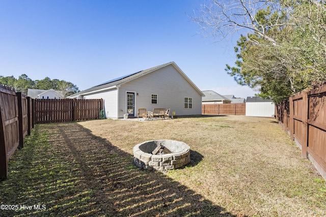 rear view of house featuring a yard and a fire pit