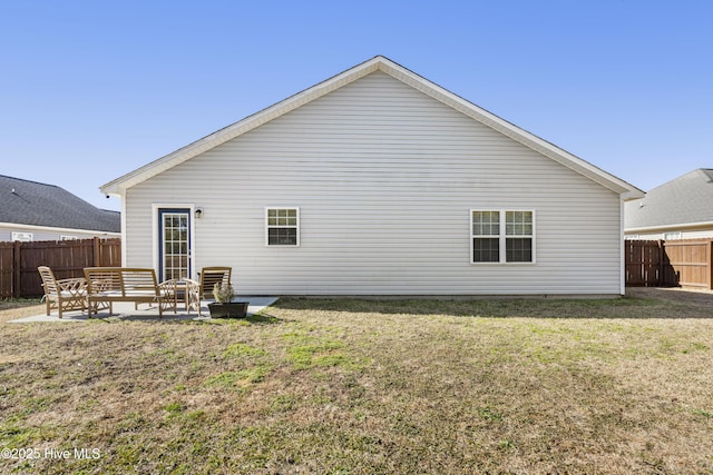 rear view of property featuring a yard and a patio area