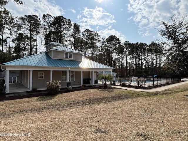 country-style home with an outdoor pool, a standing seam roof, a porch, and metal roof