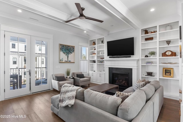 living room featuring beamed ceiling, a healthy amount of sunlight, dark hardwood / wood-style flooring, and built in features