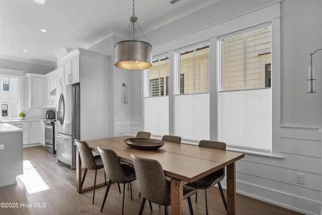 dining room featuring recessed lighting, wood finished floors, baseboards, and ornamental molding