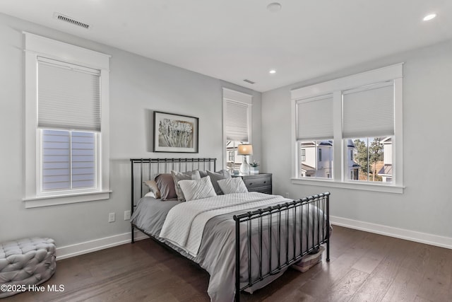 bedroom with dark wood-style floors, visible vents, recessed lighting, and baseboards