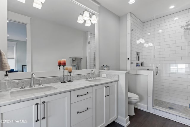 bathroom featuring vanity, wood-type flooring, walk in shower, and toilet