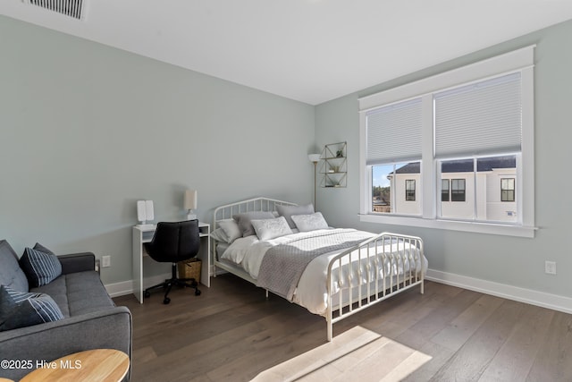 bedroom with hardwood / wood-style floors, baseboards, and visible vents