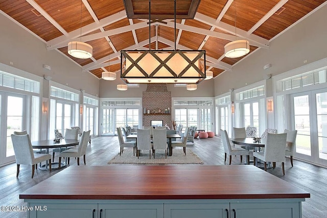 dining room featuring beam ceiling, wood ceiling, wood-type flooring, and high vaulted ceiling