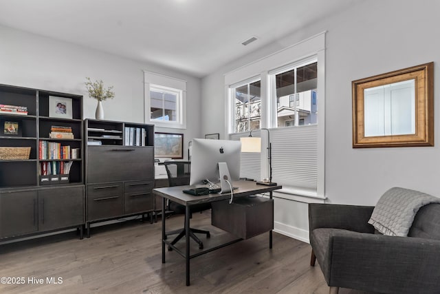 office featuring visible vents, baseboards, and wood finished floors