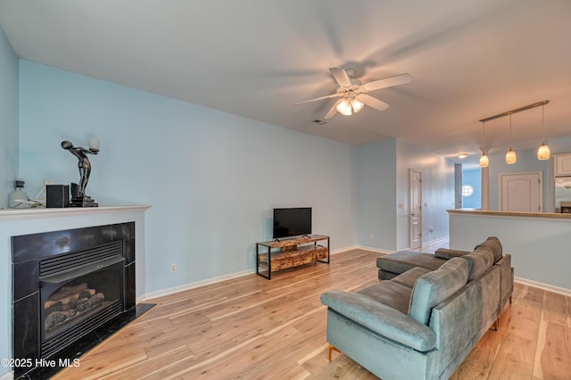 living room with light hardwood / wood-style flooring and ceiling fan