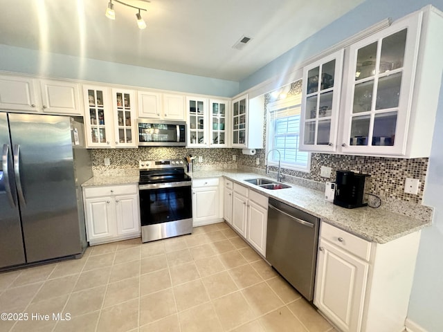 kitchen featuring light stone counters, sink, white cabinets, and appliances with stainless steel finishes