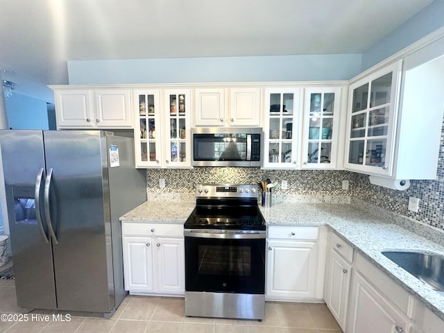 kitchen with white cabinetry, light stone countertops, and appliances with stainless steel finishes