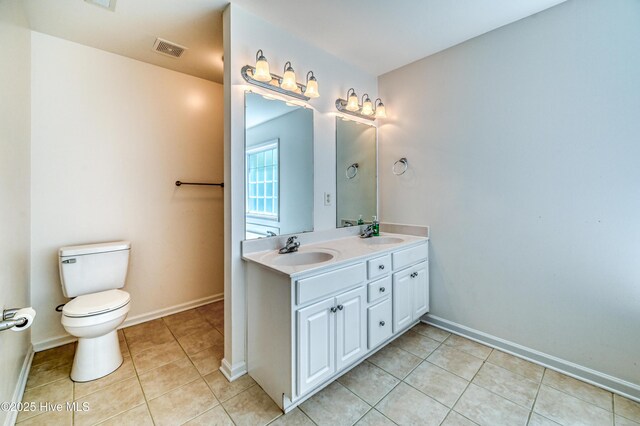 bathroom with tile patterned flooring, vanity, and toilet