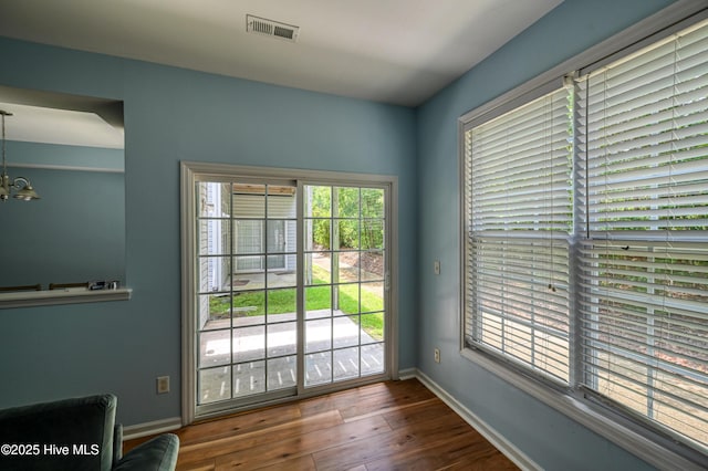 doorway to outside featuring an inviting chandelier and hardwood / wood-style floors