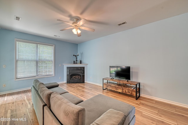 living room with ceiling fan and light wood-type flooring