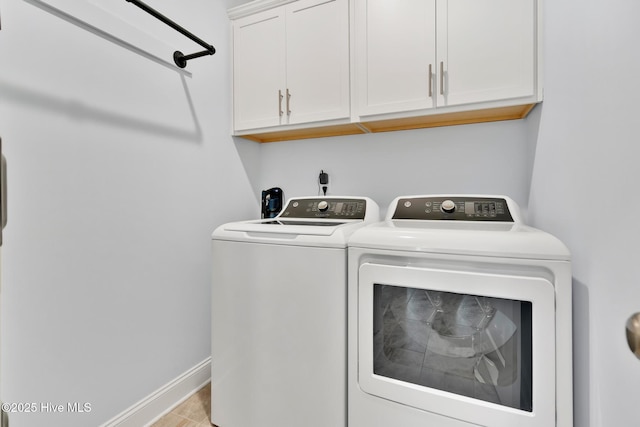 clothes washing area with cabinets, separate washer and dryer, and light hardwood / wood-style flooring