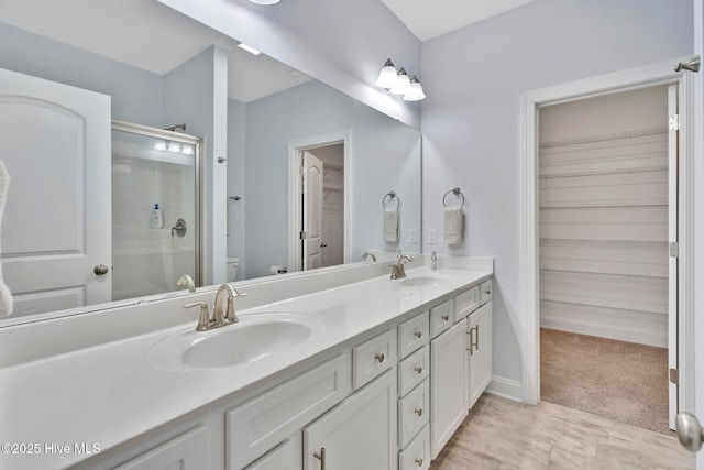 bathroom featuring vanity, an enclosed shower, and toilet