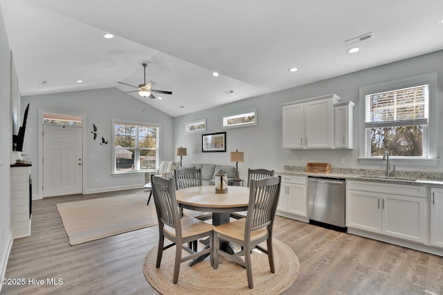 dining space featuring sink, vaulted ceiling, light hardwood / wood-style floors, and ceiling fan