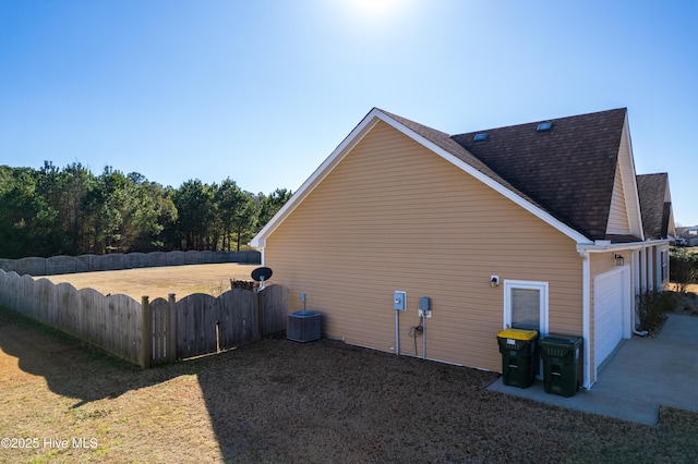 view of side of home featuring a garage and central air condition unit