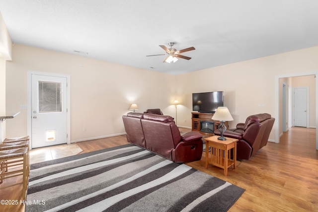 living room with ceiling fan and light hardwood / wood-style floors