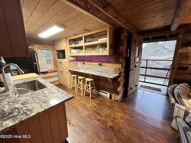 kitchen with a breakfast bar area, a sink, wood ceiling, open shelves, and dark wood finished floors