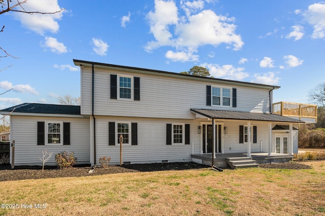 view of front of home with a front yard, crawl space, covered porch, and metal roof