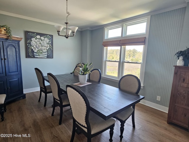 dining space featuring a notable chandelier, crown molding, and dark wood-type flooring