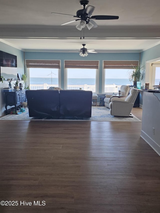 living room with a water view, ceiling fan, ornamental molding, and dark wood-type flooring