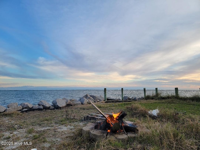 yard at dusk featuring a water view