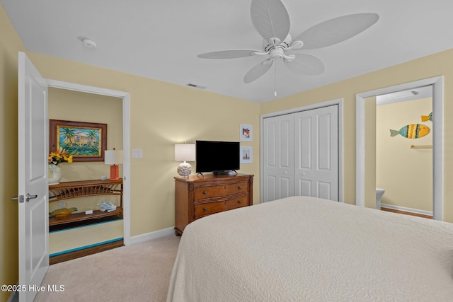 carpeted bedroom with connected bathroom, a closet, and ceiling fan