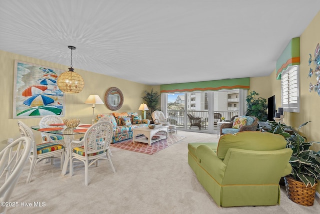 living room with light carpet, a wealth of natural light, and an inviting chandelier