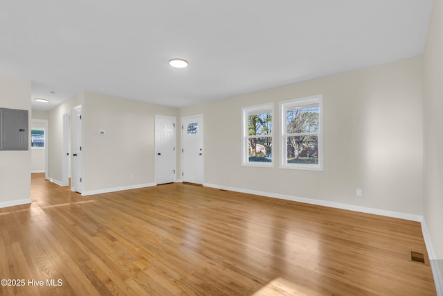 unfurnished room featuring electric panel and light wood-type flooring