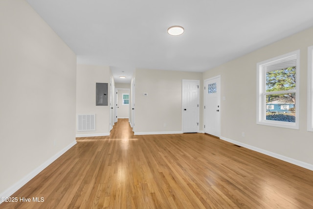 interior space with a healthy amount of sunlight, electric panel, and light wood-type flooring