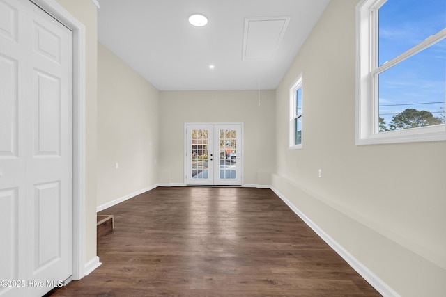 empty room with plenty of natural light, dark wood-type flooring, and french doors