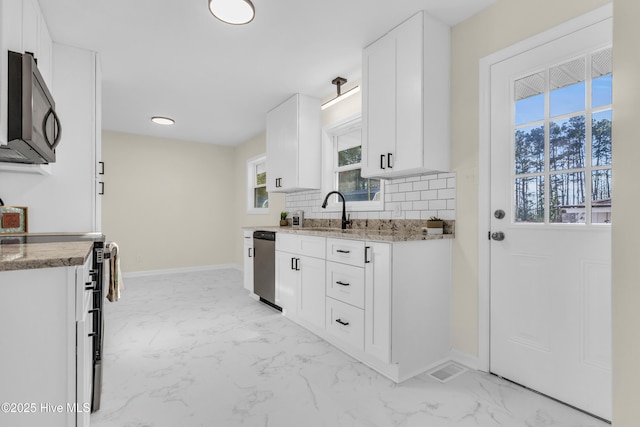 kitchen with electric range oven, white cabinetry, dishwasher, sink, and decorative backsplash